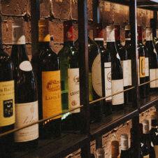 A row of wine bottles on a shelf in a restaurant.