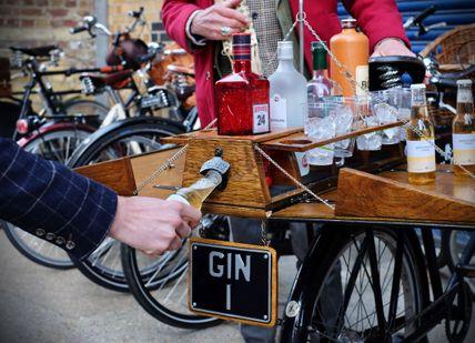 An image of a man holding a bottle of beer, Bike Ride and Gin Tour. Tally Ho