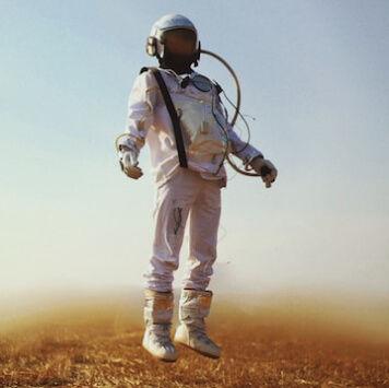 A man in a space suit standing in a field.