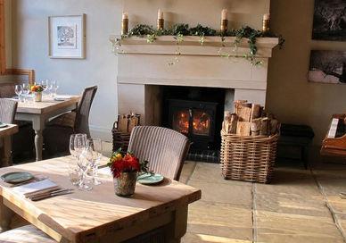 An image of a restaurant setting with a fire place, The Dysart Petersham. The Dysart Petersham